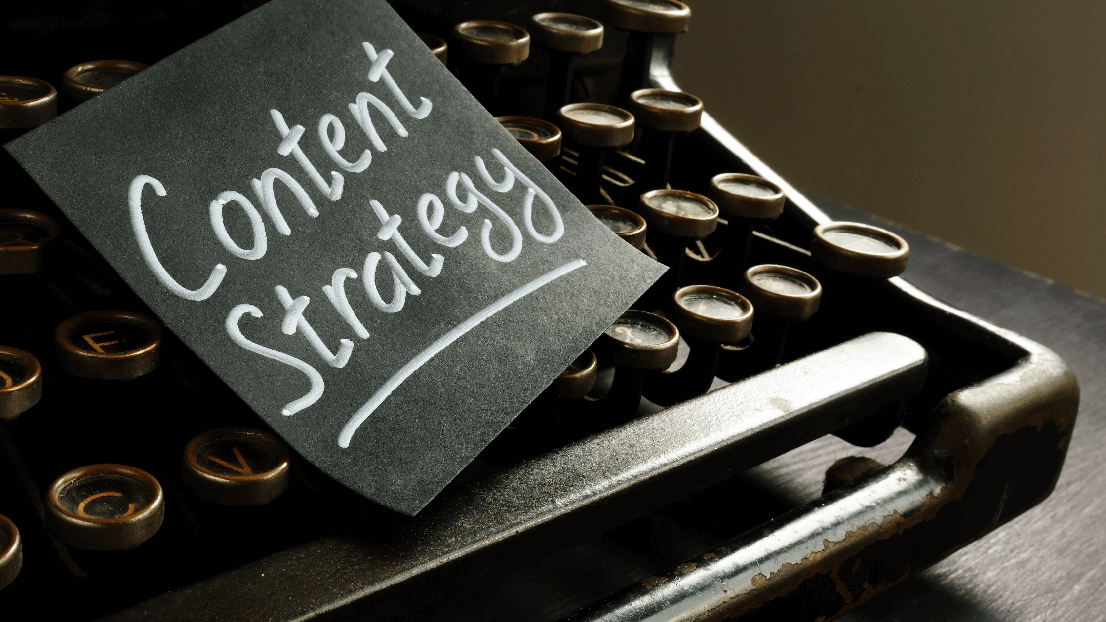 A note labeled “Content Strategy” placed on a vintage typewriter, symbolizing marketing planning and SEO content creation.