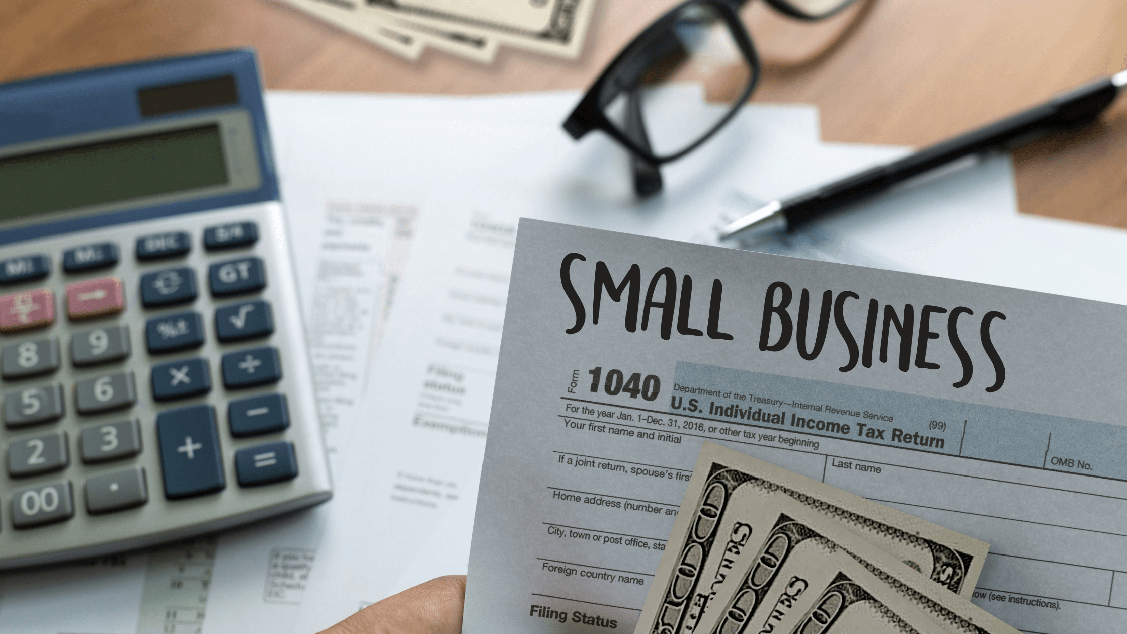 1 (2) Close-up of a small business tax form with cash, calculator, glasses, and pen on a desk.