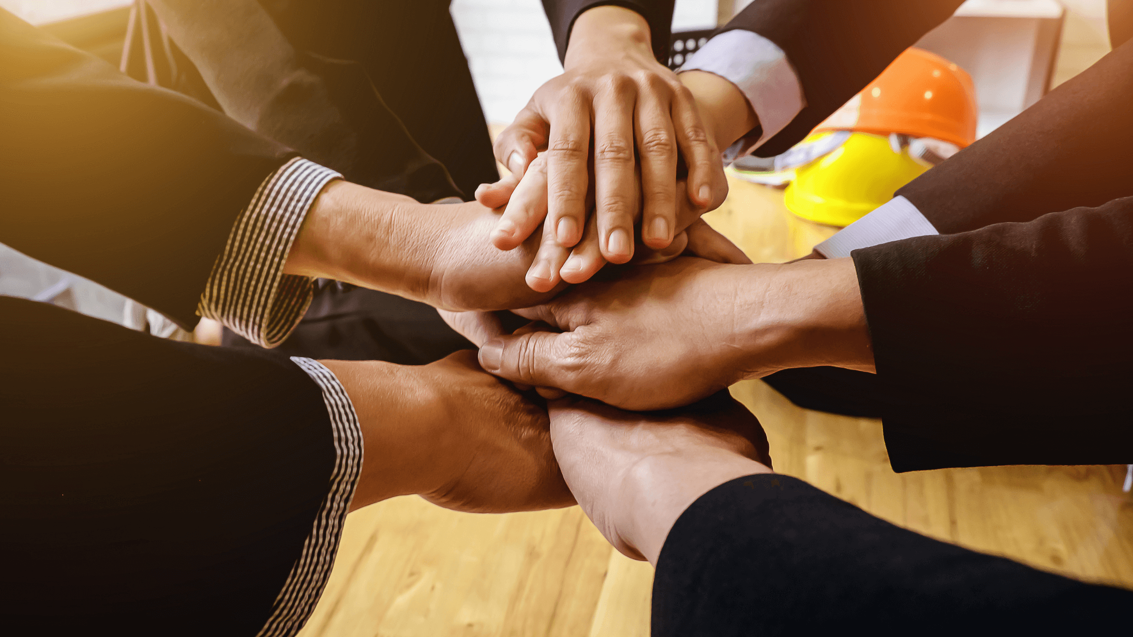 Business team stacking hands to show unity and collaboration.